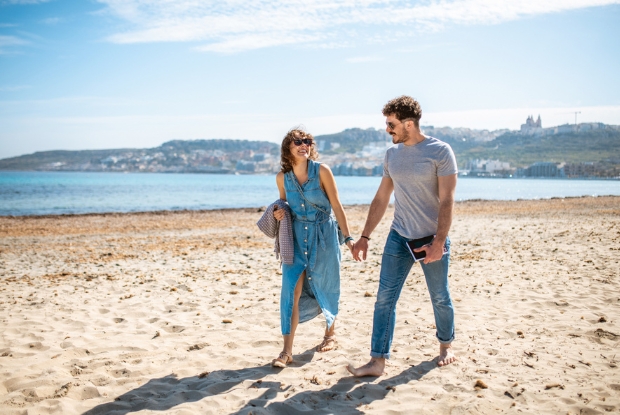couple walking on beach holding hands